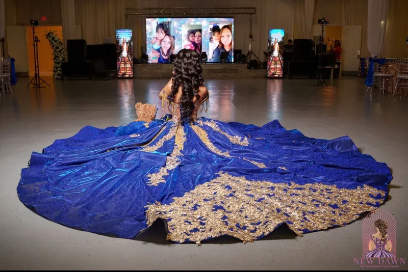 Quinceañera con vestido azul y dorado frente a la pantalla LED de fotos en la pista de baile de un evento de DJ Oso