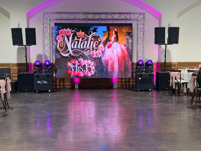 Pantalla LED de video personalizada con el texto Natalie Mis 15 rodeada de equipo de sonido e iluminación de DJ Oso en una quinceañera en Dallas-Fort Worth